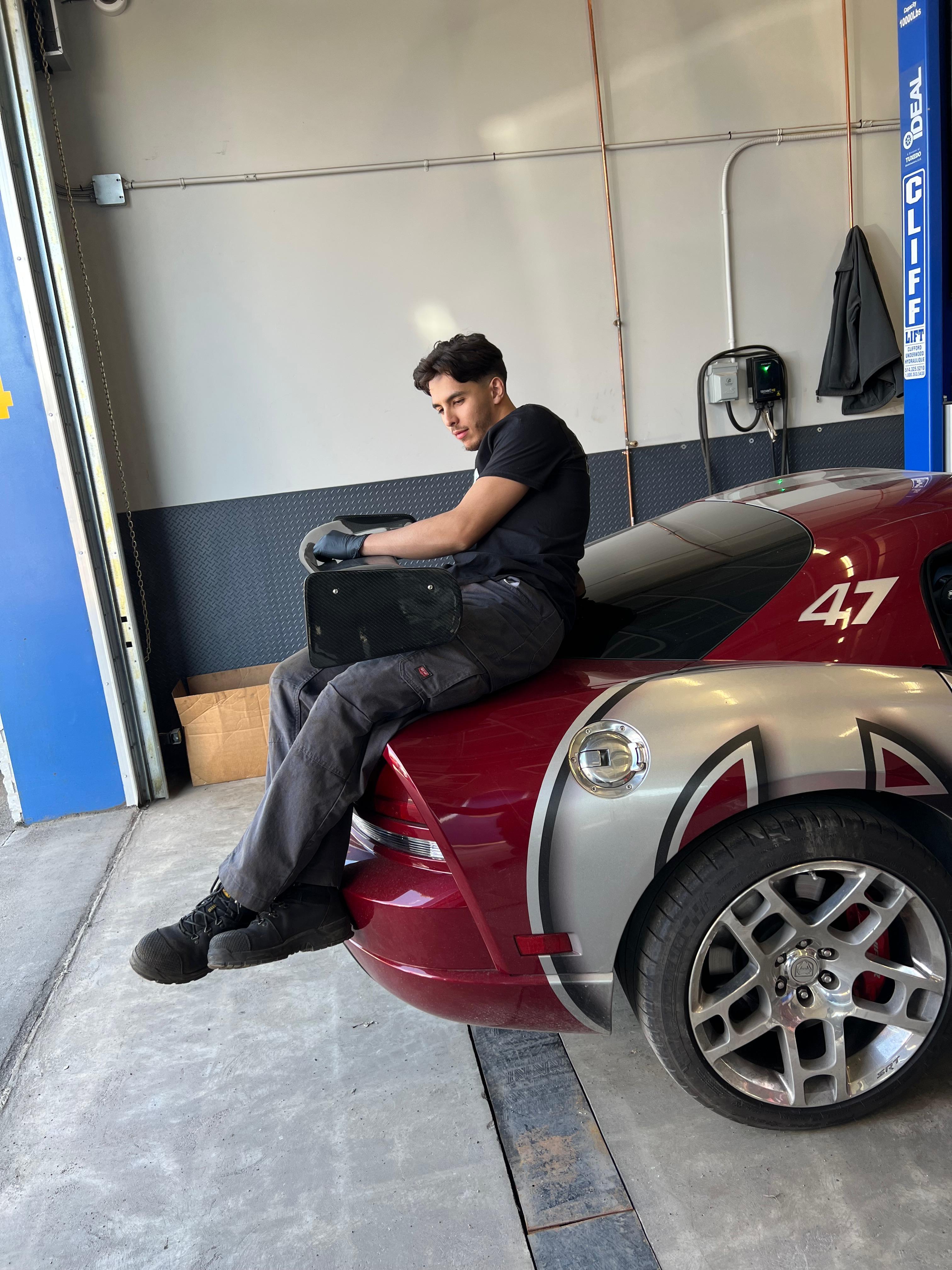 Mehdi travaillant sur le côté d'une voiture